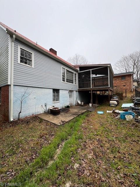 back of house featuring a patio, a sunroom, and cooling unit