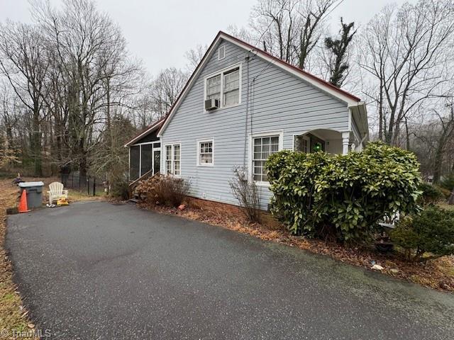 view of side of home featuring cooling unit and a sunroom