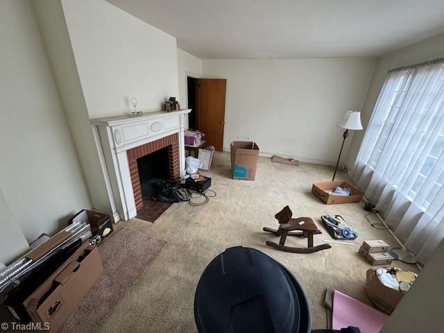 living room with a brick fireplace and carpet