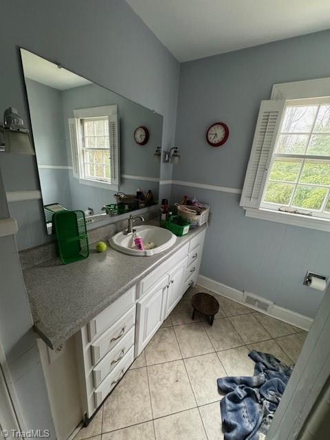 bathroom featuring vanity, a healthy amount of sunlight, and tile patterned floors