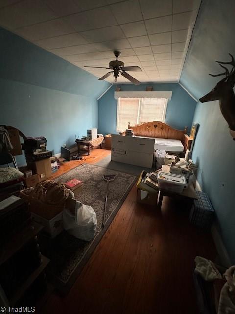 bedroom with hardwood / wood-style floors, vaulted ceiling, and ceiling fan