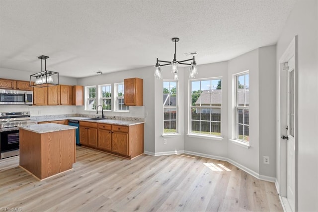 305 Apple Ridge Rd, Greensboro, NC 27406 - kitchen featuring stainless steel appliances, a chandelier, a textured ceiling, and brown cabinets