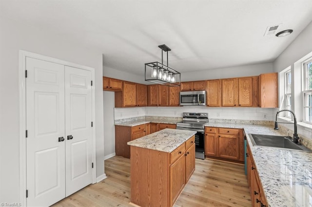 305 Apple Ridge Rd, Greensboro, NC 27406 - kitchen featuring stainless steel appliances, brown cabinetry, a kitchen island, and decorative backsplash