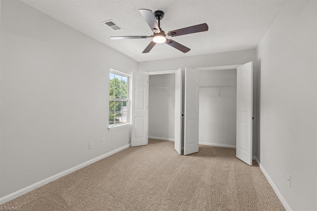 305 Apple Ridge Rd, Greensboro, NC 27406 - unfurnished bedroom featuring two closets, light carpet, and a ceiling fan