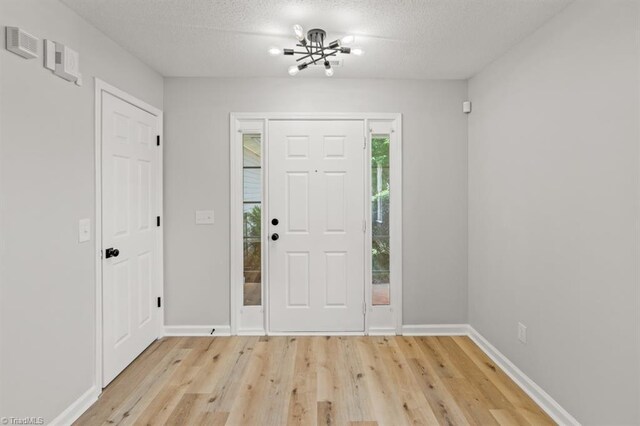 305 Apple Ridge Rd, Greensboro, NC 27406 - foyer with a chandelier, light wood-style floors, and a textured ceiling