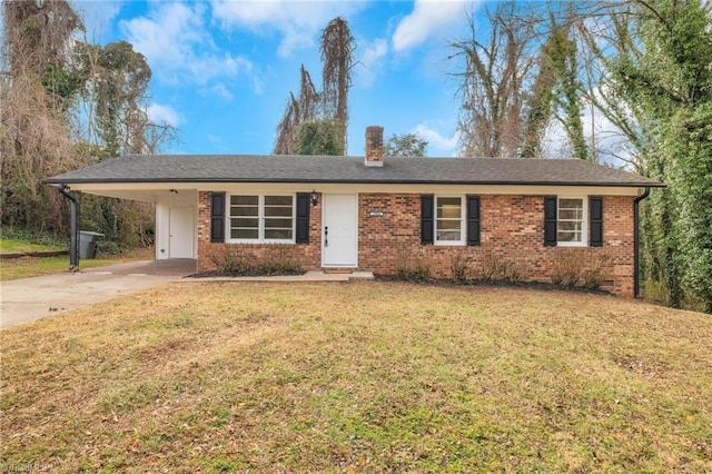 single story home featuring brick siding, concrete driveway, a carport, a chimney, and a front yard