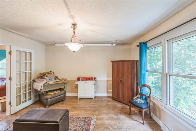 sitting room featuring a textured ceiling and light wood finished floors