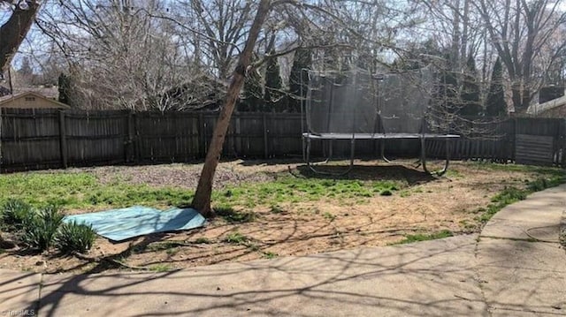 fenced backyard featuring a trampoline