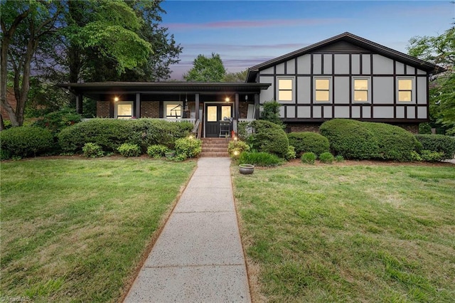 view of front of property with a lawn and brick siding