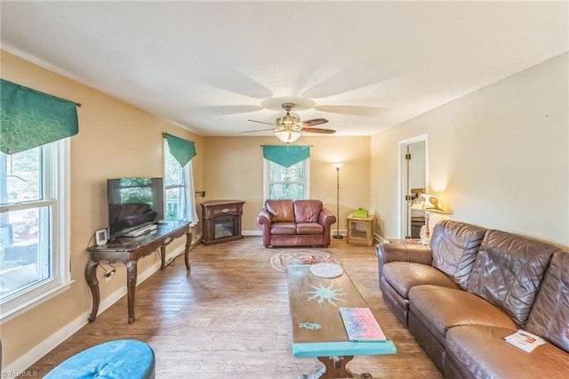 living room with baseboards, a ceiling fan, and wood finished floors