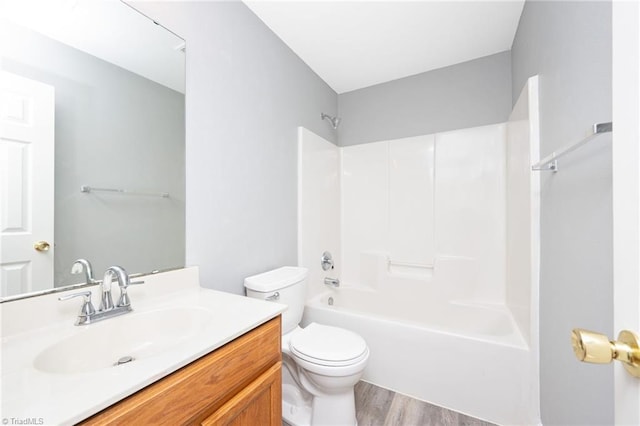 full bathroom with vanity, hardwood / wood-style floors, toilet, and washtub / shower combination