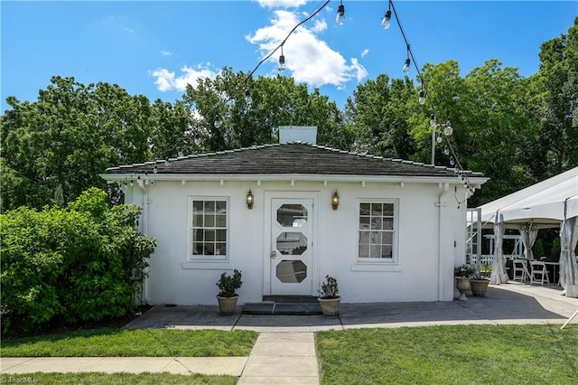 17 E Main St, Thomasville, NC 27360 - view of front of house featuring a front lawn, an outdoor structure, and stucco siding