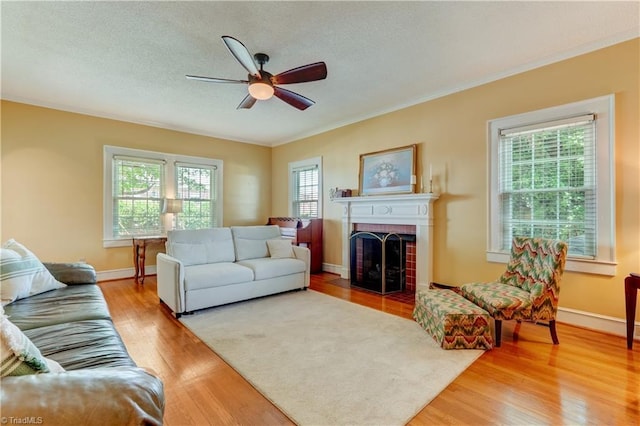 17 E Main St, Thomasville, NC 27360 - living area with light wood-type flooring, a ceiling fan, a fireplace, crown molding, and a textured ceiling