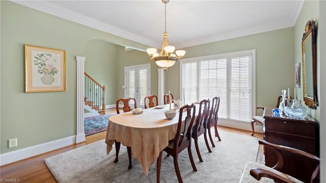 dining area featuring an inviting chandelier, crown molding, stairs, french doors, and wood finished floors