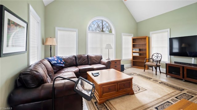living room featuring tile patterned floors, high vaulted ceiling, and baseboards