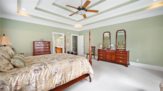 bedroom featuring ornamental molding, ensuite bath, carpet, and a tray ceiling