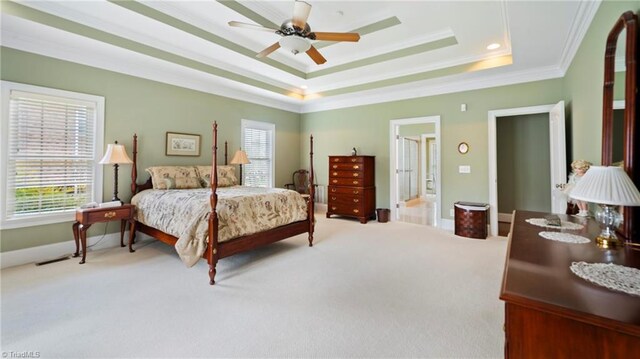 bedroom with crown molding, a tray ceiling, baseboards, and carpet flooring
