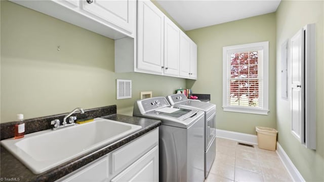 clothes washing area featuring a sink, cabinet space, visible vents, baseboards, and washer and dryer