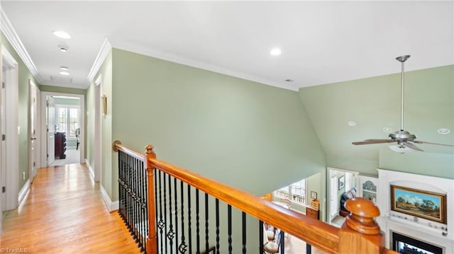 hall with ornamental molding, recessed lighting, an upstairs landing, and light wood-style floors