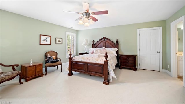 bedroom featuring baseboards, ceiling fan, ensuite bath, and carpet flooring