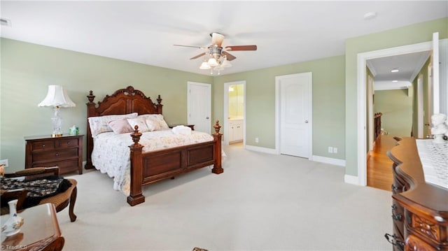 bedroom featuring ensuite bath, a ceiling fan, visible vents, light carpet, and baseboards
