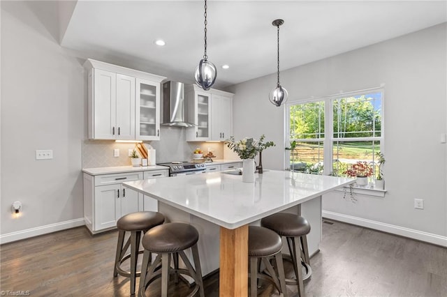 kitchen featuring dark hardwood / wood-style floors, white cabinets, wall chimney exhaust hood, hanging light fixtures, and stainless steel electric range oven