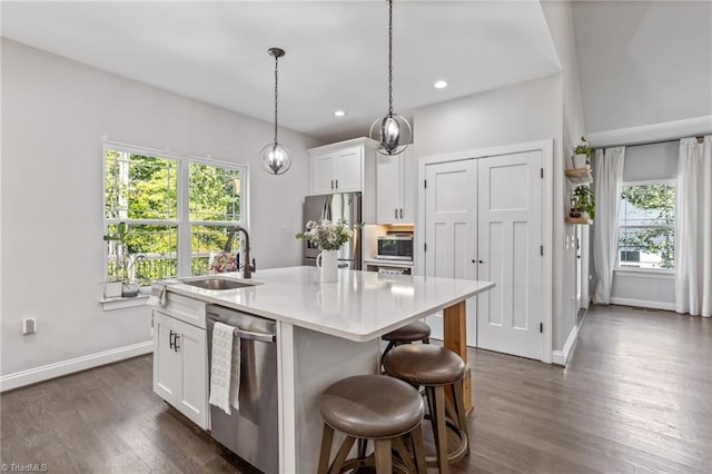 kitchen with white cabinets, a kitchen island with sink, stainless steel appliances, and plenty of natural light