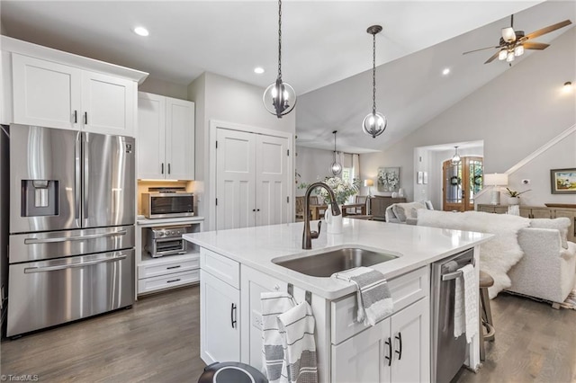 kitchen with dark hardwood / wood-style flooring, a center island with sink, sink, white cabinets, and appliances with stainless steel finishes