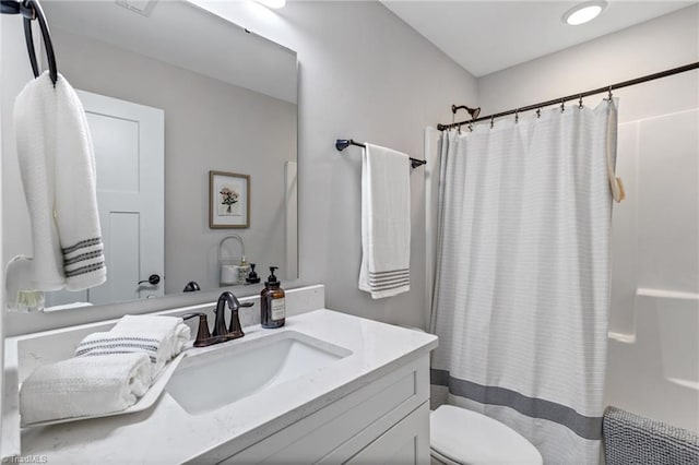 bathroom with curtained shower, vanity, and toilet