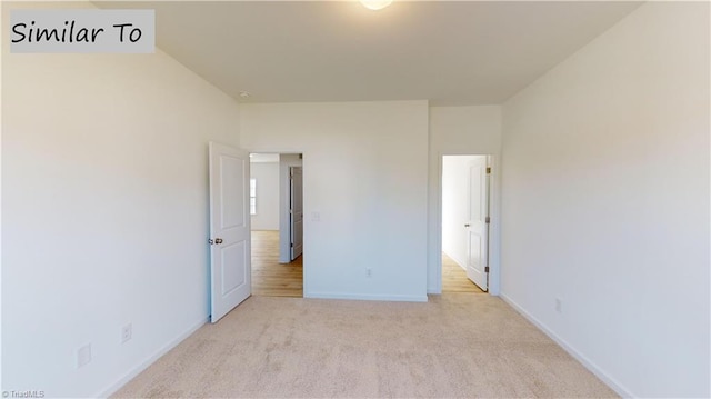 unfurnished bedroom featuring baseboards and light colored carpet