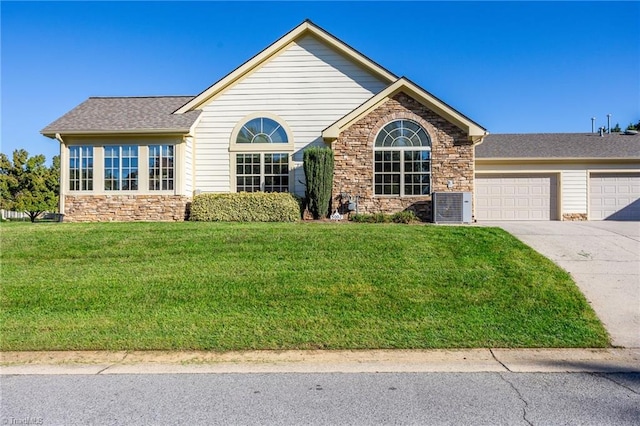 view of front of property with a garage, cooling unit, and a front lawn