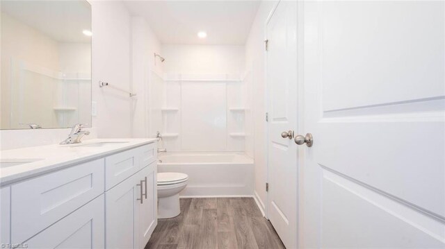 full bathroom with toilet, vanity, shower / bathtub combination, and hardwood / wood-style flooring