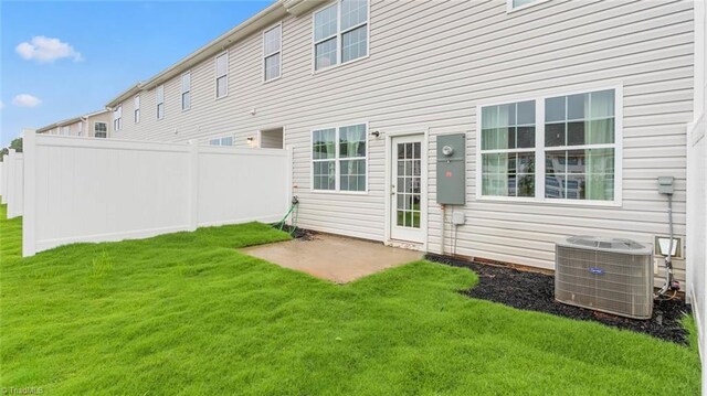 rear view of property featuring a yard and central air condition unit