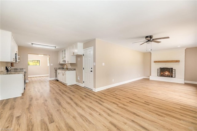 4353 Valley View Rd, Thomasville, NC 27370 - unfurnished living room with a sink, a ceiling fan, light wood finished floors, baseboards, and a large fireplace