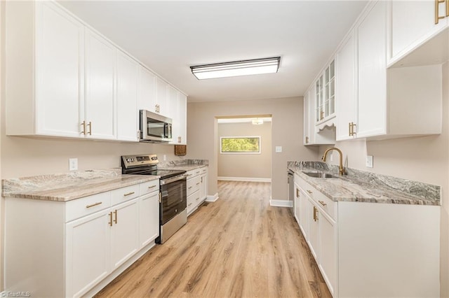 4353 Valley View Rd, Thomasville, NC 27370 - kitchen featuring appliances with stainless steel finishes, a sink, light wood-type flooring, and white cabinetry