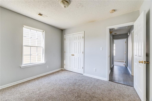 unfurnished bedroom featuring a closet, a textured ceiling, and carpet flooring