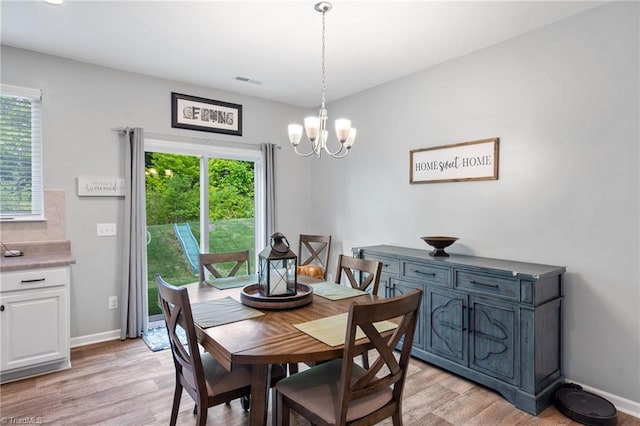 dining area with light hardwood / wood-style flooring and a chandelier