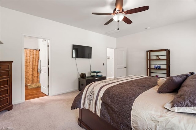 carpeted bedroom with ceiling fan and ensuite bathroom