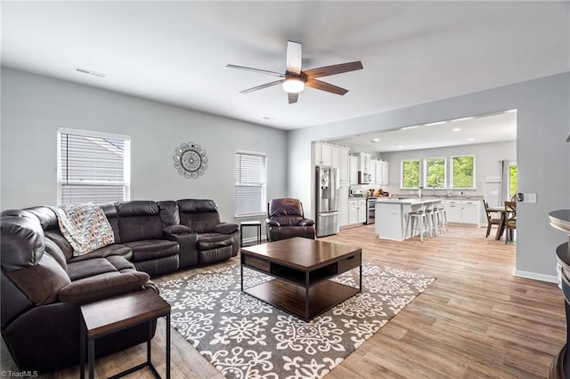 living room with ceiling fan and light wood-type flooring