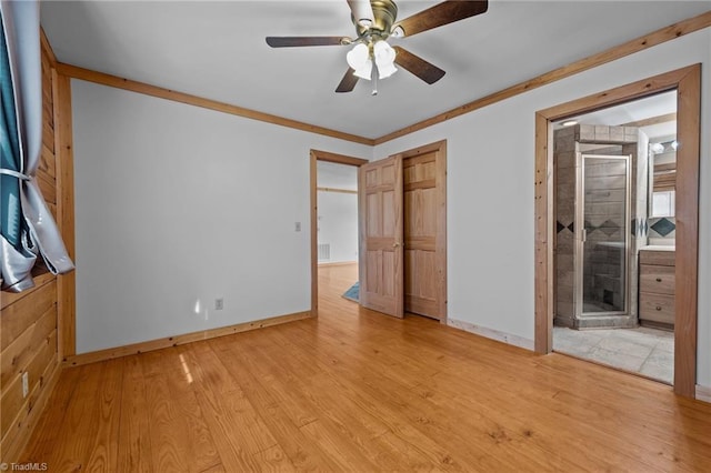 unfurnished bedroom featuring ornamental molding, ensuite bathroom, and light wood-type flooring