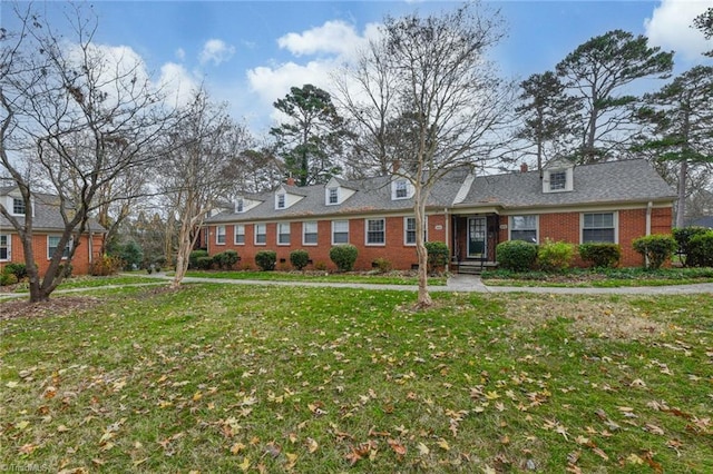 cape cod-style house featuring a front lawn and brick siding