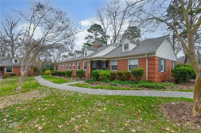 cape cod home featuring a front lawn and brick siding