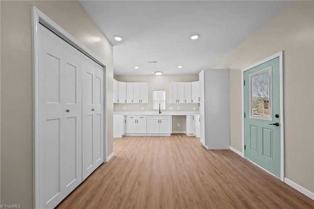 kitchen featuring sink, white cabinets, and light hardwood / wood-style flooring