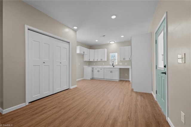 kitchen featuring white cabinetry, sink, and light hardwood / wood-style flooring