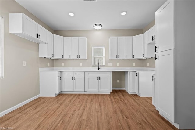 kitchen featuring sink, light hardwood / wood-style floors, and white cabinets