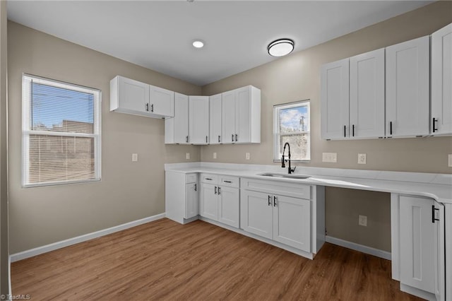 kitchen featuring white cabinetry, sink, and light hardwood / wood-style flooring