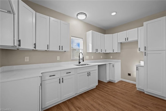 kitchen featuring white cabinetry, sink, and light wood-type flooring