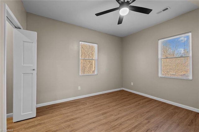 empty room with ceiling fan and light hardwood / wood-style floors