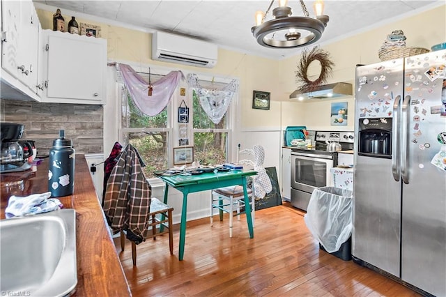 kitchen featuring white cabinetry, sink, stainless steel appliances, an AC wall unit, and hardwood / wood-style floors