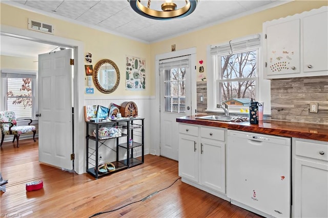 kitchen with sink, wood counters, white dishwasher, white cabinets, and light wood-type flooring